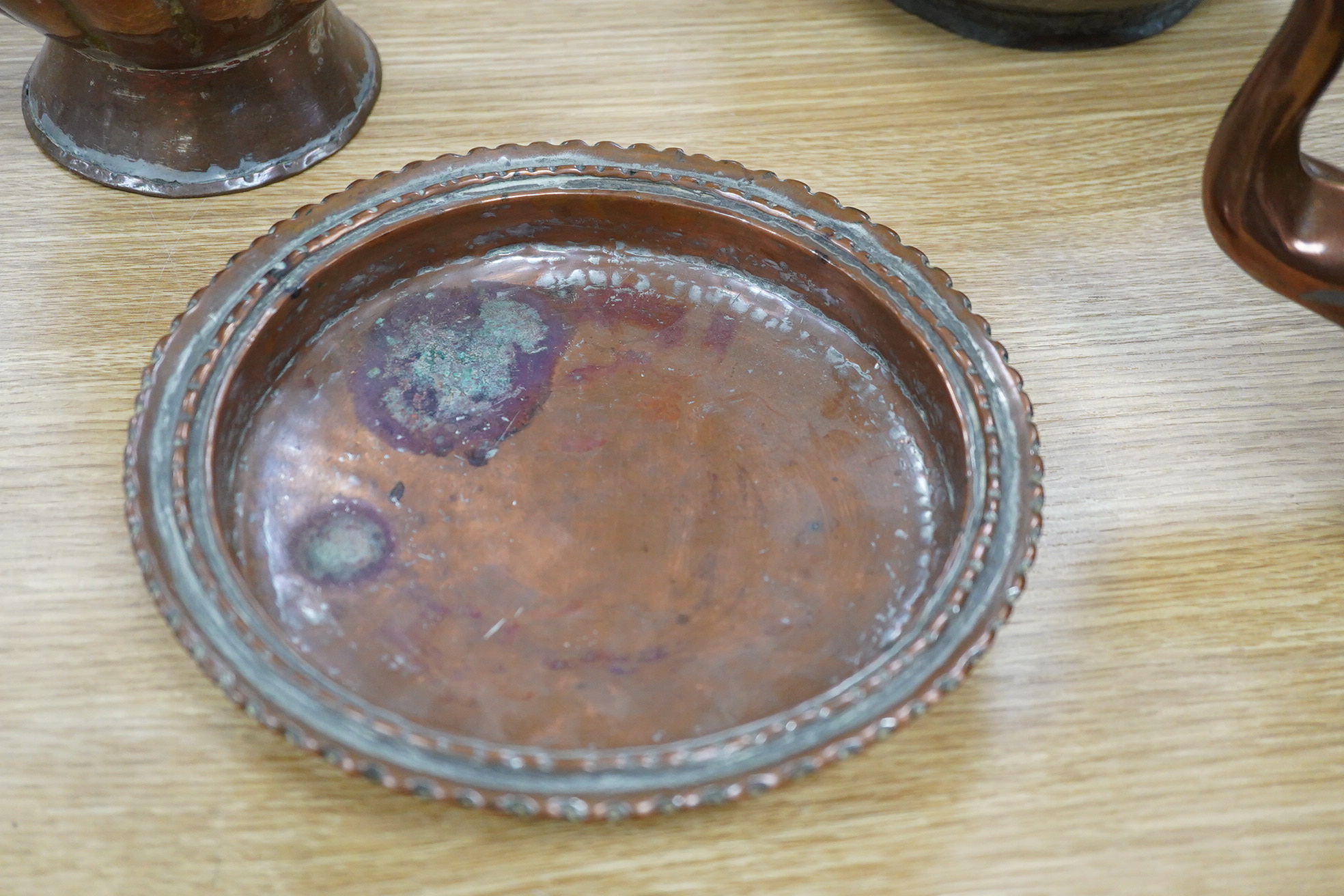 Two Middle eastern tinned copper coffee pots ‘Dallah’ a similar dish and a European copper kettle, tallest 41cm high